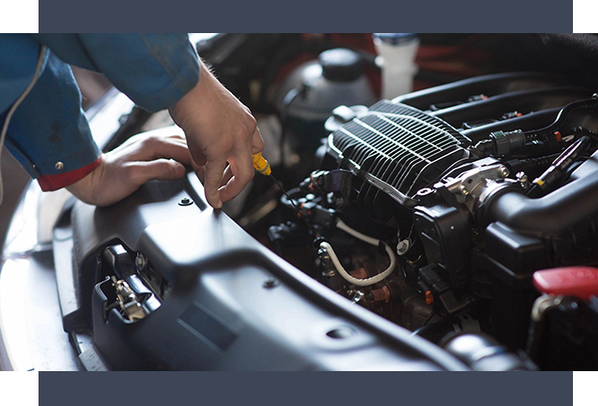 A person working on the engine of an automobile.